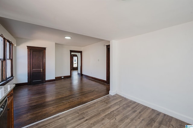 unfurnished room with dark wood-type flooring and baseboards