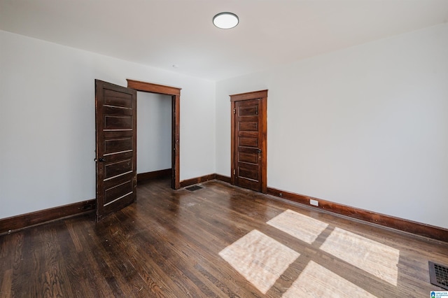 unfurnished bedroom with visible vents, baseboards, and wood finished floors