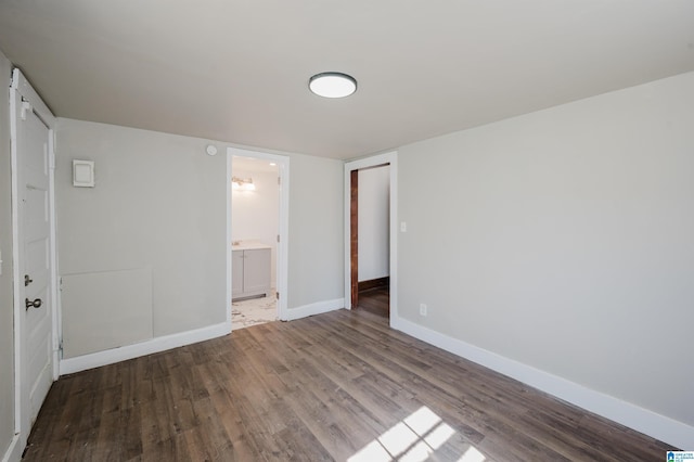 spare room featuring baseboards and wood finished floors