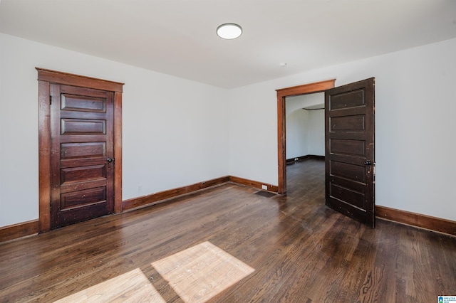 empty room with baseboards and wood finished floors