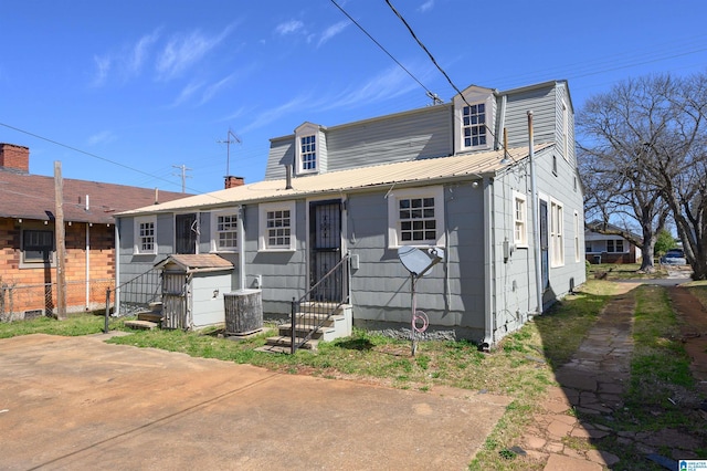 view of front of house with entry steps, metal roof, and central AC unit