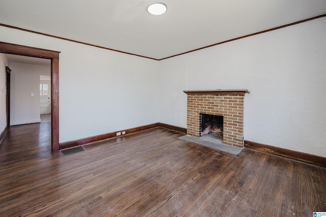 unfurnished living room featuring baseboards, visible vents, wood finished floors, crown molding, and a fireplace