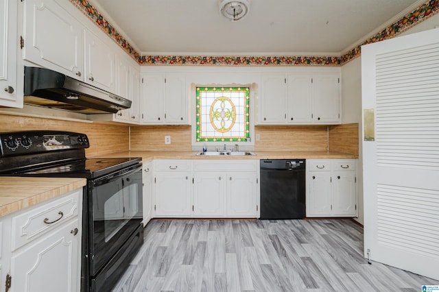 kitchen with black appliances, under cabinet range hood, white cabinets, and a sink