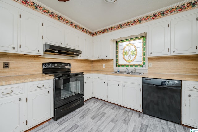 kitchen with tasteful backsplash, white cabinetry, a sink, under cabinet range hood, and black appliances