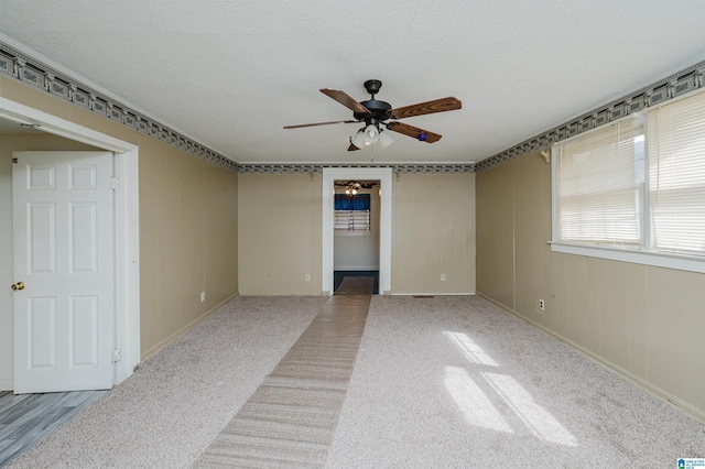 empty room featuring a ceiling fan and a textured ceiling