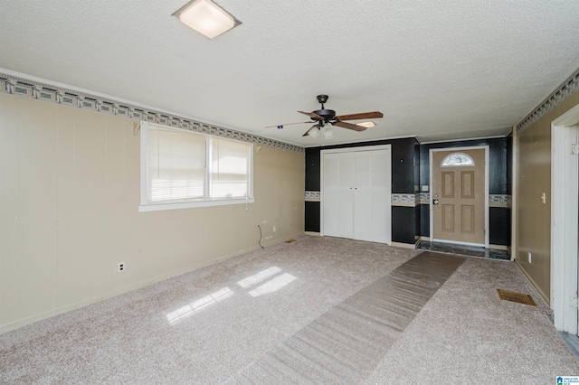 interior space featuring a ceiling fan and a textured ceiling