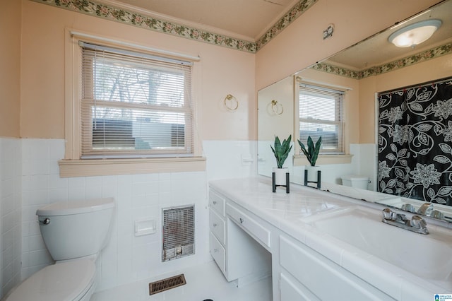 full bath featuring wainscoting, visible vents, tile walls, and toilet