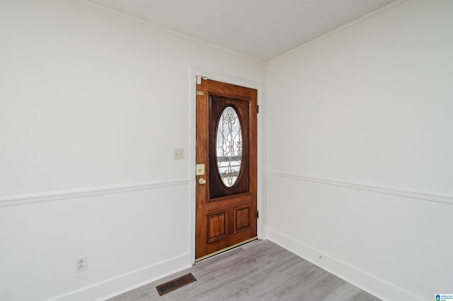 entryway with baseboards, visible vents, and light wood finished floors