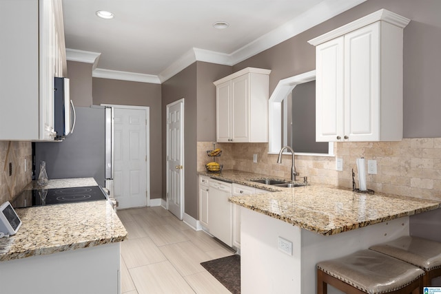 kitchen featuring white dishwasher, a sink, white cabinets, light stone countertops, and stainless steel microwave