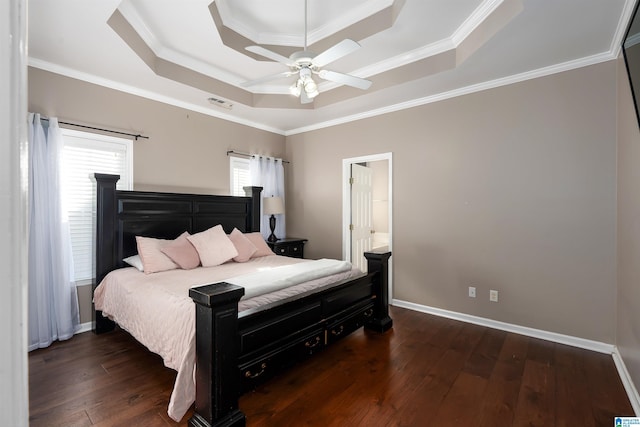 bedroom featuring a tray ceiling, multiple windows, hardwood / wood-style floors, and baseboards