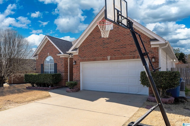 view of front of house with roof with shingles, brick siding, central air condition unit, an attached garage, and driveway