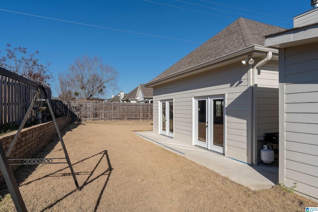 view of yard with french doors and a fenced backyard