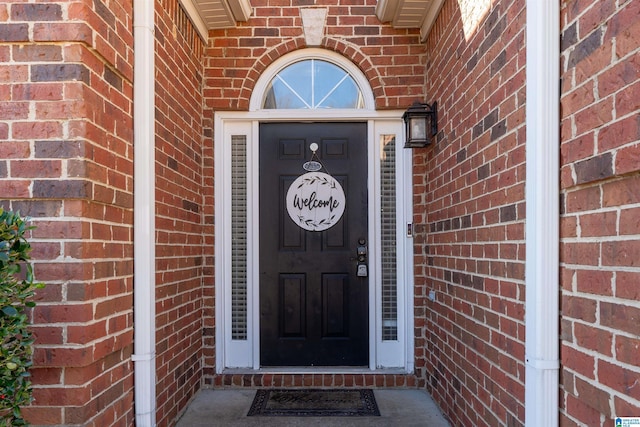 doorway to property featuring brick siding