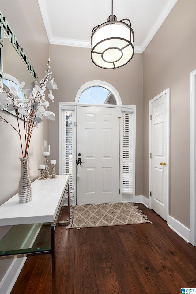 foyer entrance featuring ornamental molding, dark wood-style flooring, and baseboards