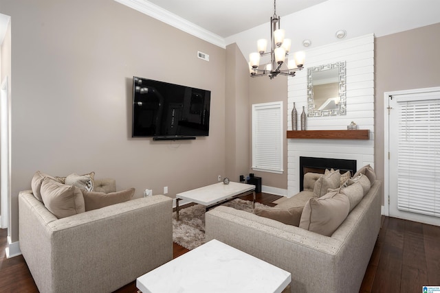 living area with visible vents, dark wood finished floors, crown molding, a fireplace, and a chandelier