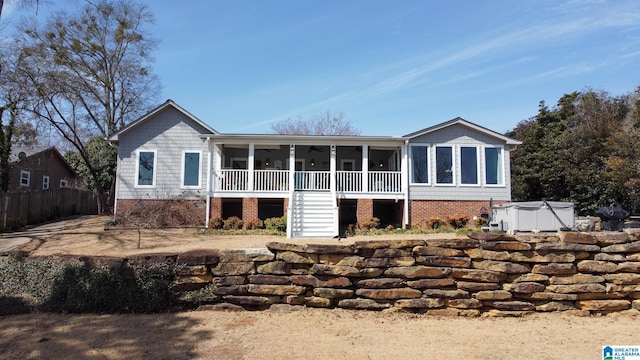 back of property featuring a hot tub, ceiling fan, stairs, and a porch