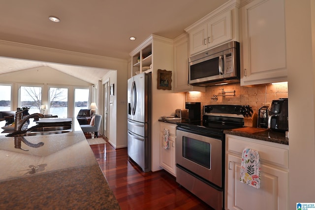 kitchen with stainless steel appliances, tasteful backsplash, dark wood-type flooring, white cabinetry, and a sink