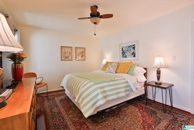 bedroom with wood finished floors, a ceiling fan, and baseboards