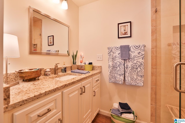 bathroom featuring baseboards, a shower stall, and vanity