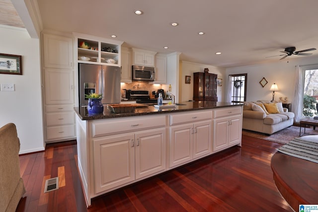 kitchen featuring a center island with sink, dark wood-style floors, appliances with stainless steel finishes, white cabinetry, and recessed lighting