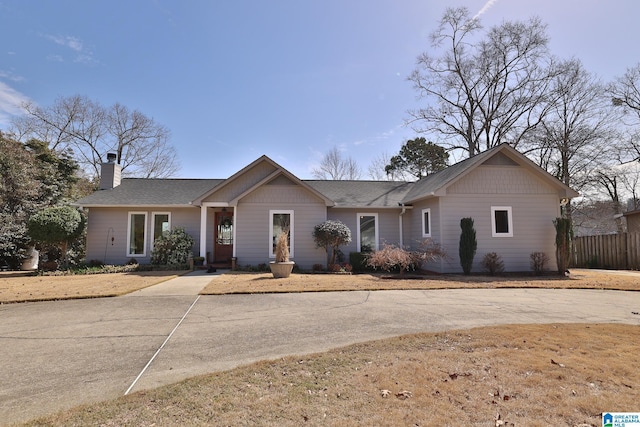 ranch-style house with fence and a chimney