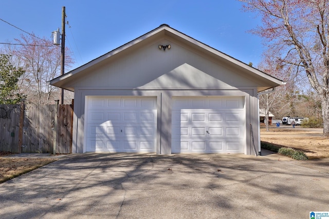 detached garage featuring fence