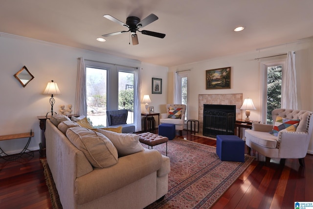 living room featuring a wealth of natural light, a fireplace with flush hearth, crown molding, and hardwood / wood-style floors