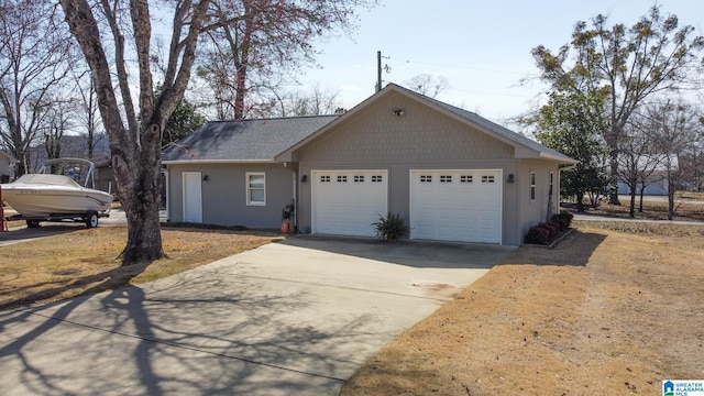 view of front of house featuring a garage, driveway, and a shingled roof