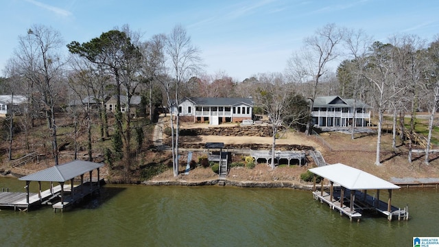 dock area with a water view, boat lift, and stairway