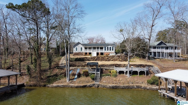 rear view of house featuring a water view and stairway