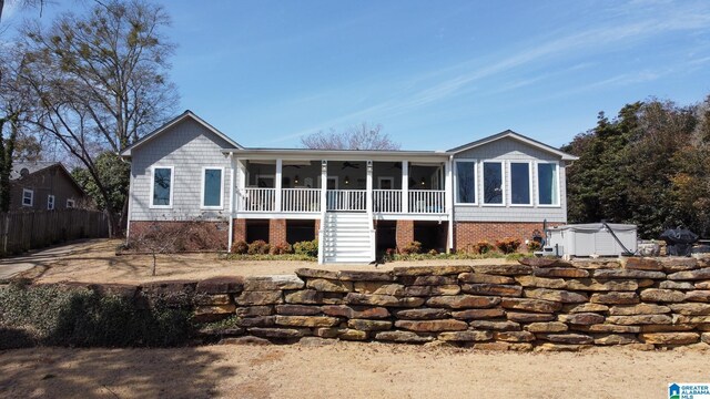 back of house with ceiling fan, a porch, and stairway