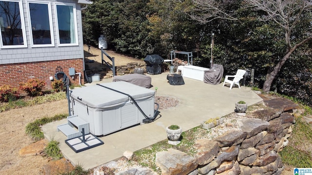 view of patio / terrace with a hot tub and grilling area