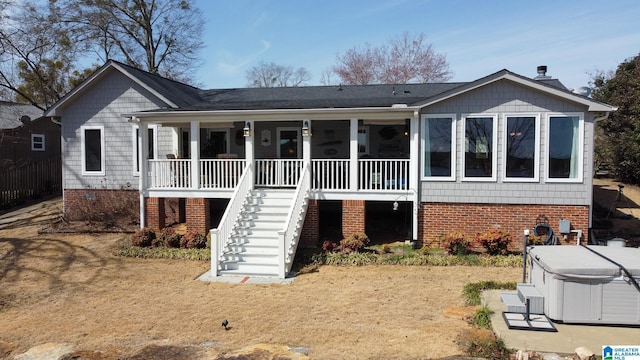 view of front of house with stairway, a sunroom, and a hot tub