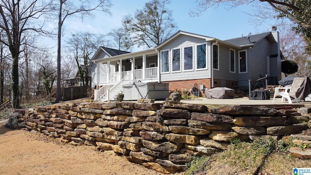 view of front of house with stairs, a chimney, and a patio area