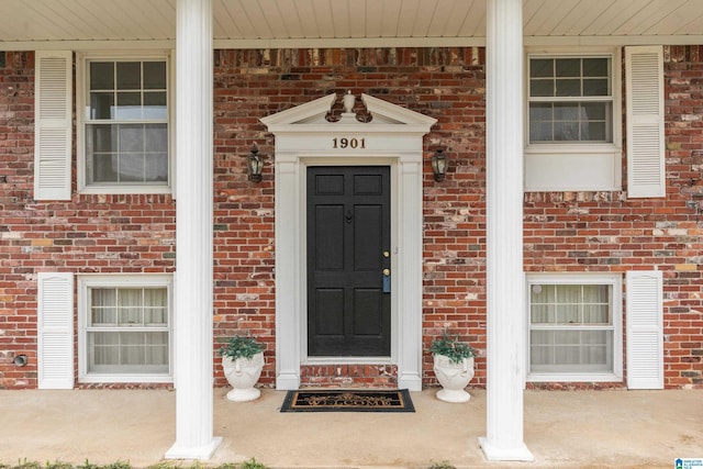 property entrance featuring brick siding