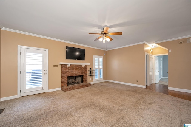 unfurnished living room featuring crown molding, baseboards, carpet flooring, a fireplace, and a ceiling fan