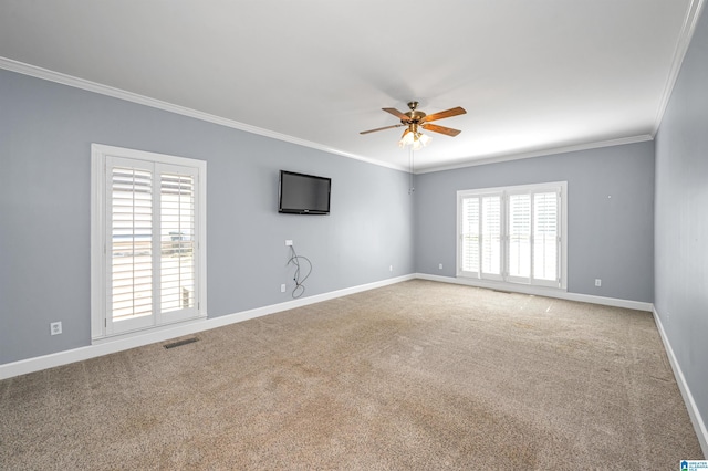 empty room featuring visible vents, ceiling fan, baseboards, ornamental molding, and carpet flooring