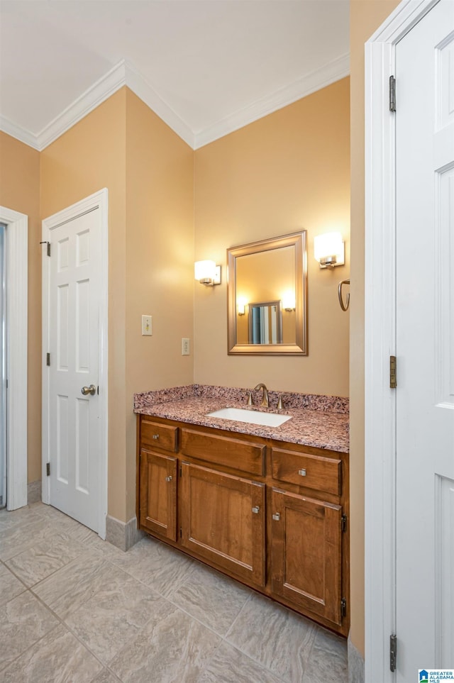 bathroom with vanity, crown molding, and baseboards