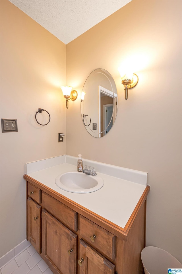 bathroom with tile patterned floors, a textured ceiling, and vanity