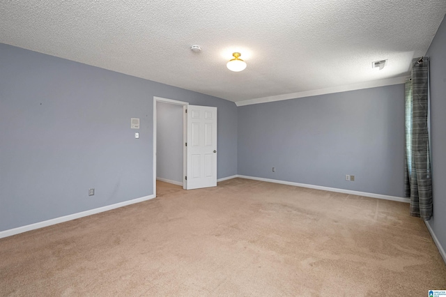 empty room featuring baseboards, light carpet, a textured ceiling, and visible vents