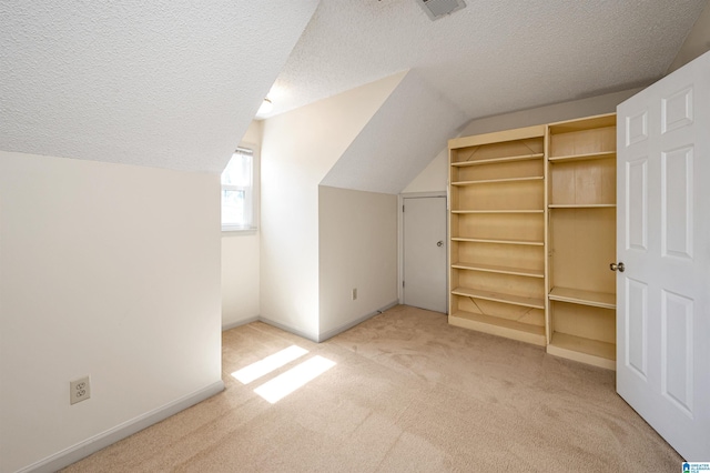 additional living space featuring baseboards, carpet floors, a textured ceiling, and vaulted ceiling