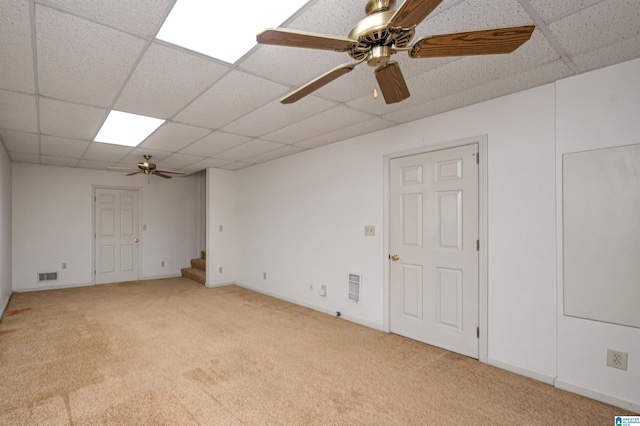 unfurnished room with visible vents, baseboards, stairway, a drop ceiling, and light carpet