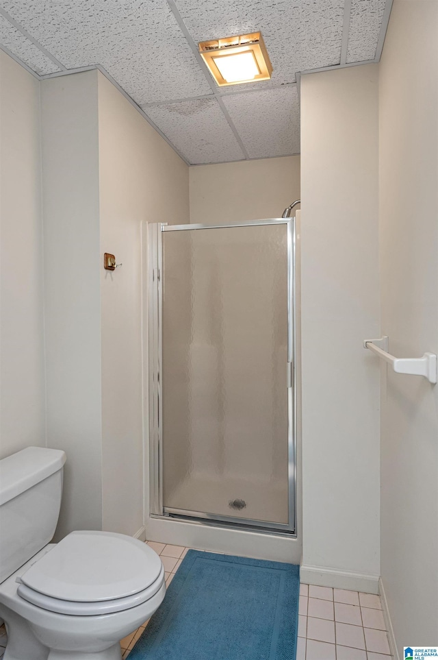 full bathroom featuring tile patterned floors, toilet, and a shower stall