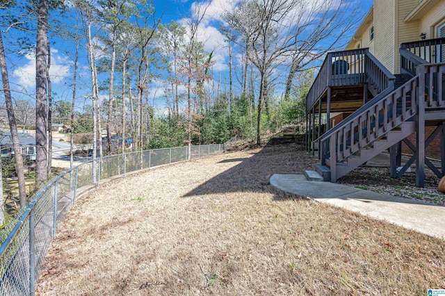 view of yard with stairway, a wooden deck, and a fenced backyard