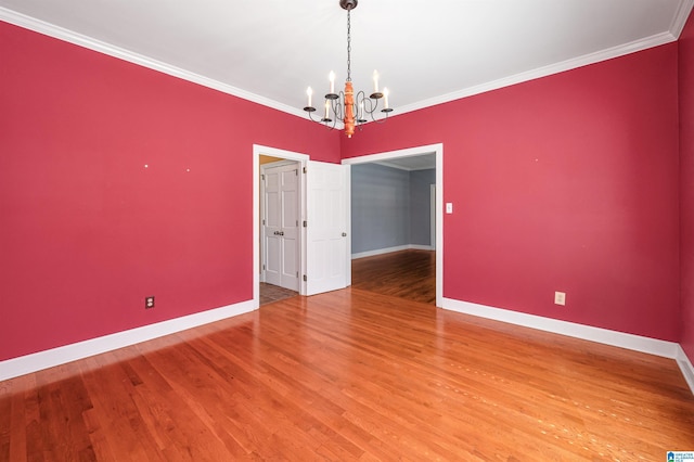 unfurnished room featuring baseboards, light wood-type flooring, a chandelier, and ornamental molding