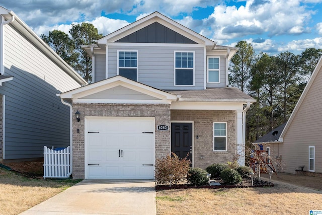 craftsman-style house featuring brick siding, an attached garage, driveway, and board and batten siding