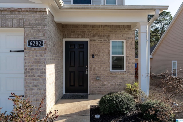 doorway to property featuring brick siding