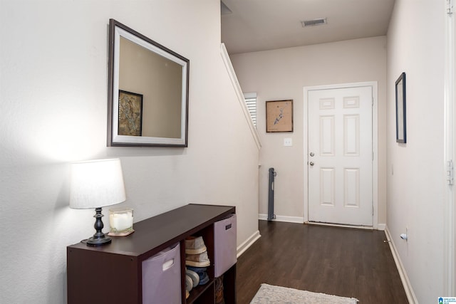 interior space with dark wood finished floors, visible vents, and baseboards