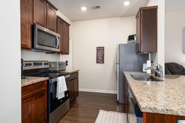 kitchen with visible vents, dark wood-type flooring, baseboards, appliances with stainless steel finishes, and a sink