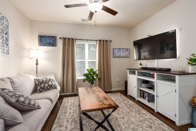 living area featuring dark wood-type flooring, baseboards, visible vents, and ceiling fan